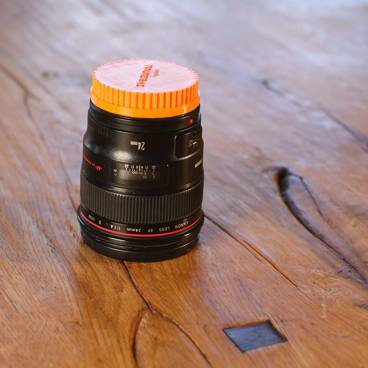 Canon EF 24 mm F1.4L II USM stehend, mit orangefarbener Frontkappe