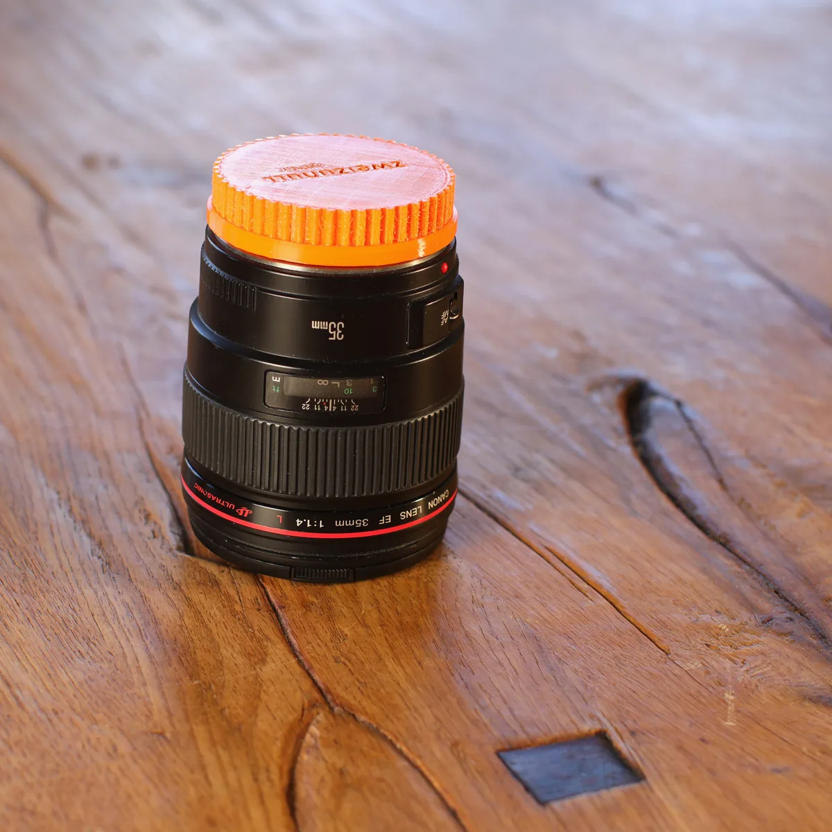 Canon EF 35 mm F1.4L USM stehend, mit orangefarbener Frontkappe